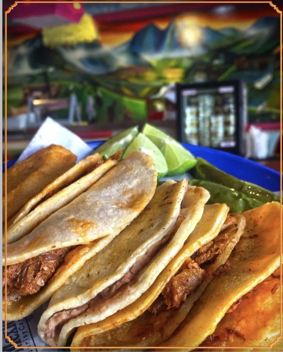 Tacos de canasta de La Mexicana con limón y chile toreado, con el mural al fondo